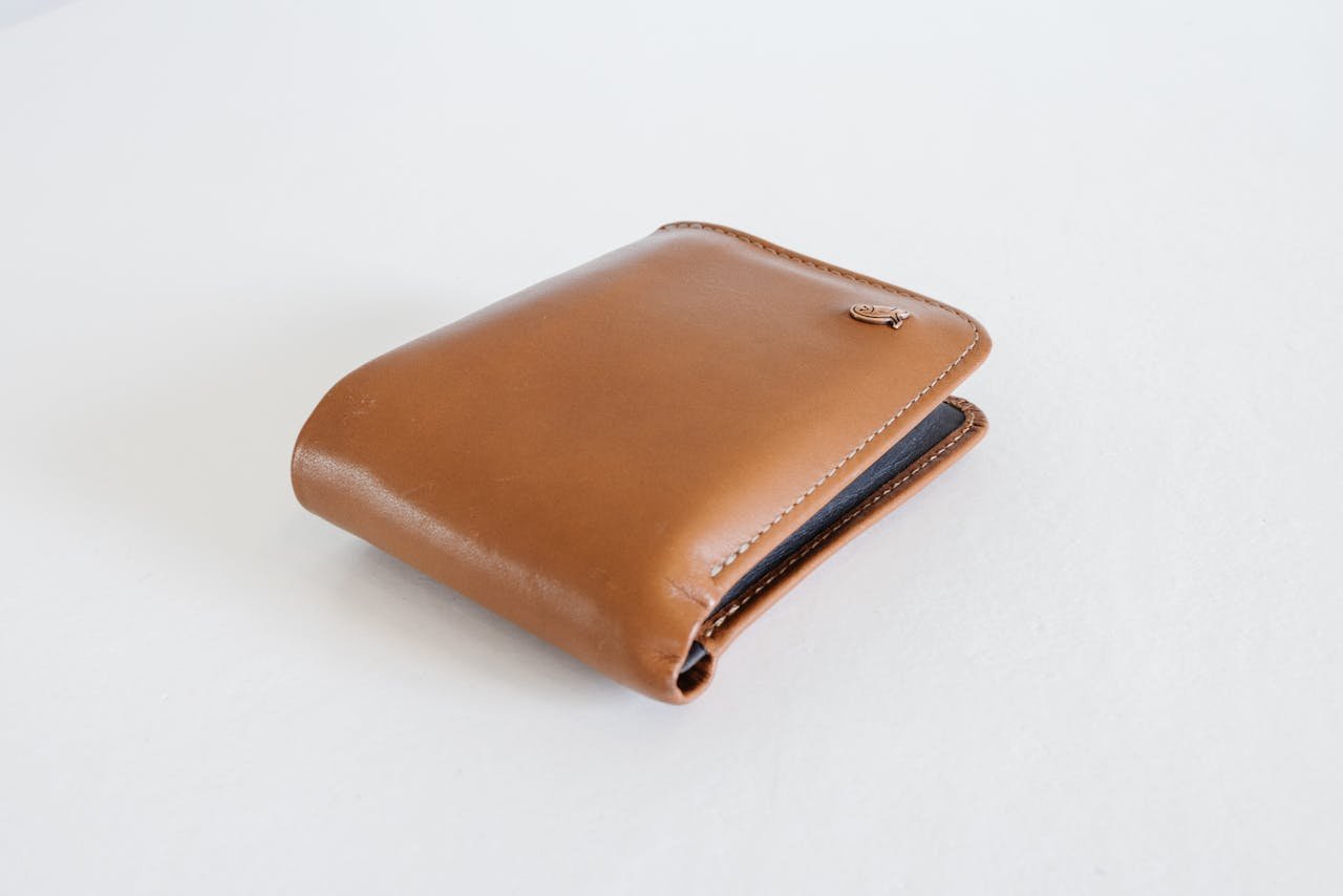 Home A sleek brown leather wallet photographed against a clean white background, ideal for business use.
