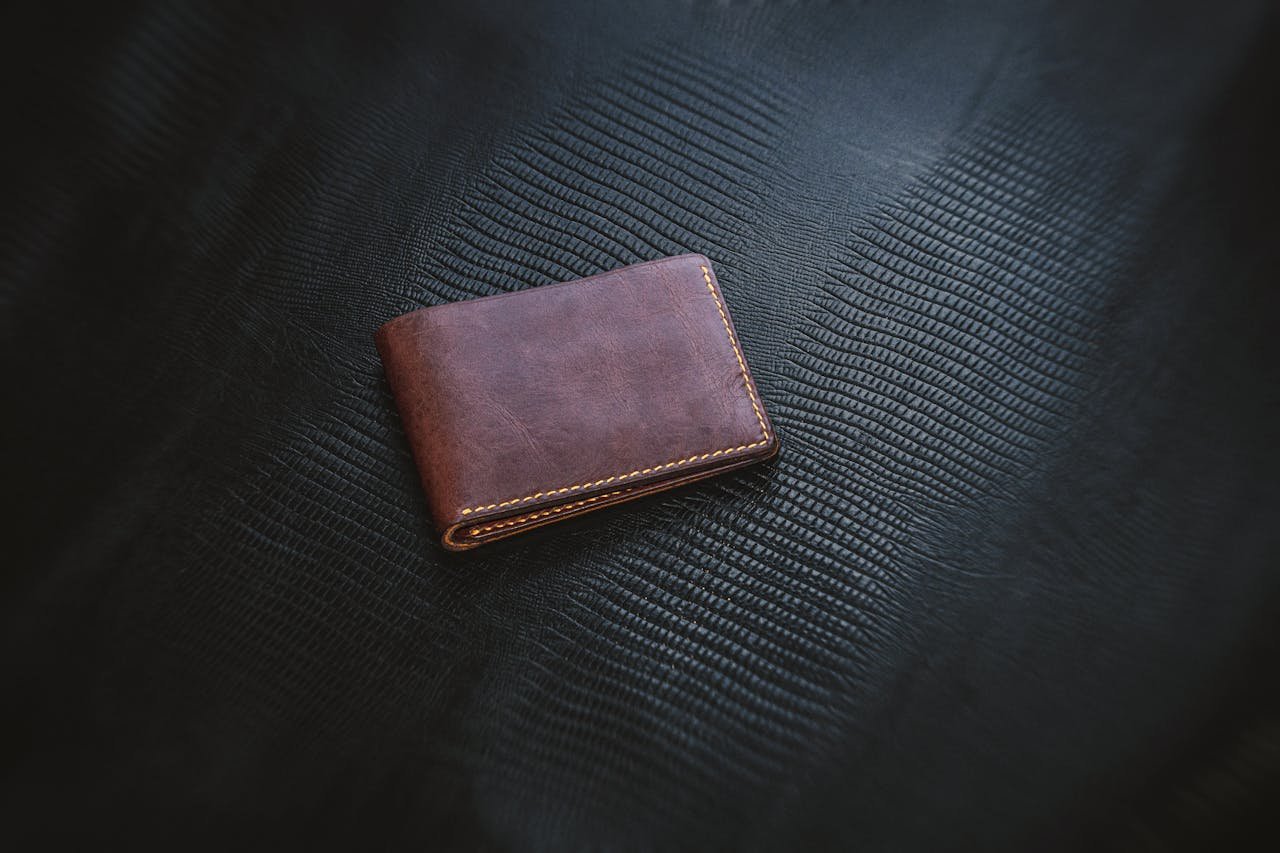 Home Elegant brown leather wallet showcasing minimalist design on a textured surface. Perfect for fashion and lifestyle themes.