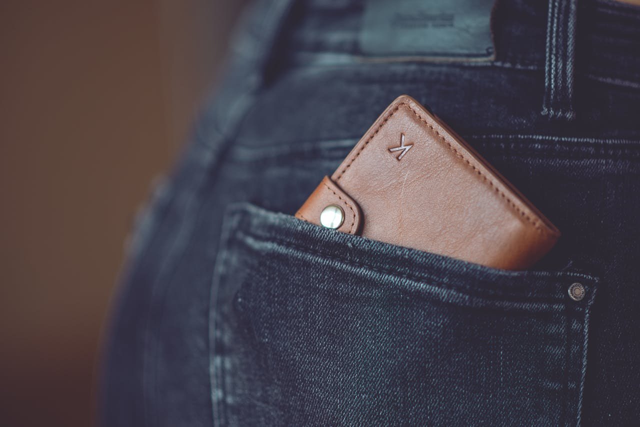 Home A stylish brown leather wallet partially visible in a jeans back pocket.